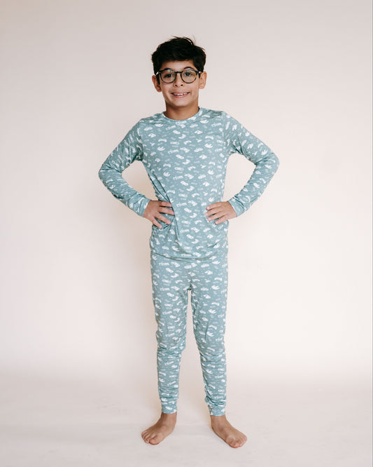 boy wearing sage green pjs with video game controllers